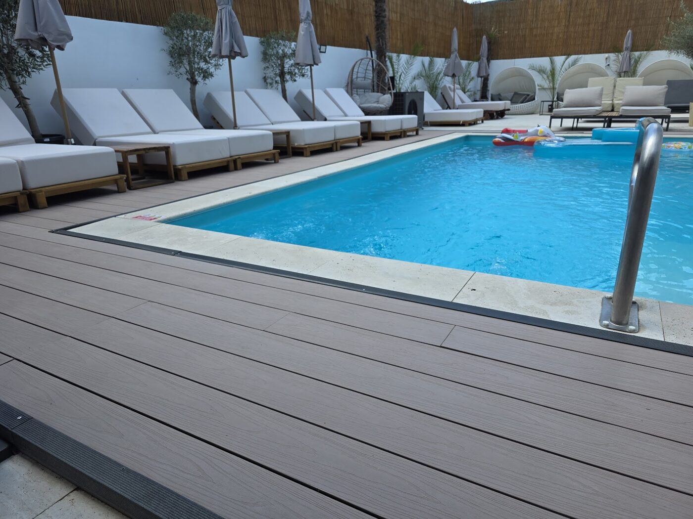Piscina ziua cu șezlonguri și cabane lounge